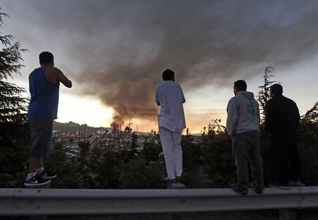 Spectators view the fire at the Chevron Oil refinery from the top of a guardrail as the fire fills the sky with black smoke above Richmond Calif, Monday August 6, 2012. Photo: Lance Iversen, The Chronicle